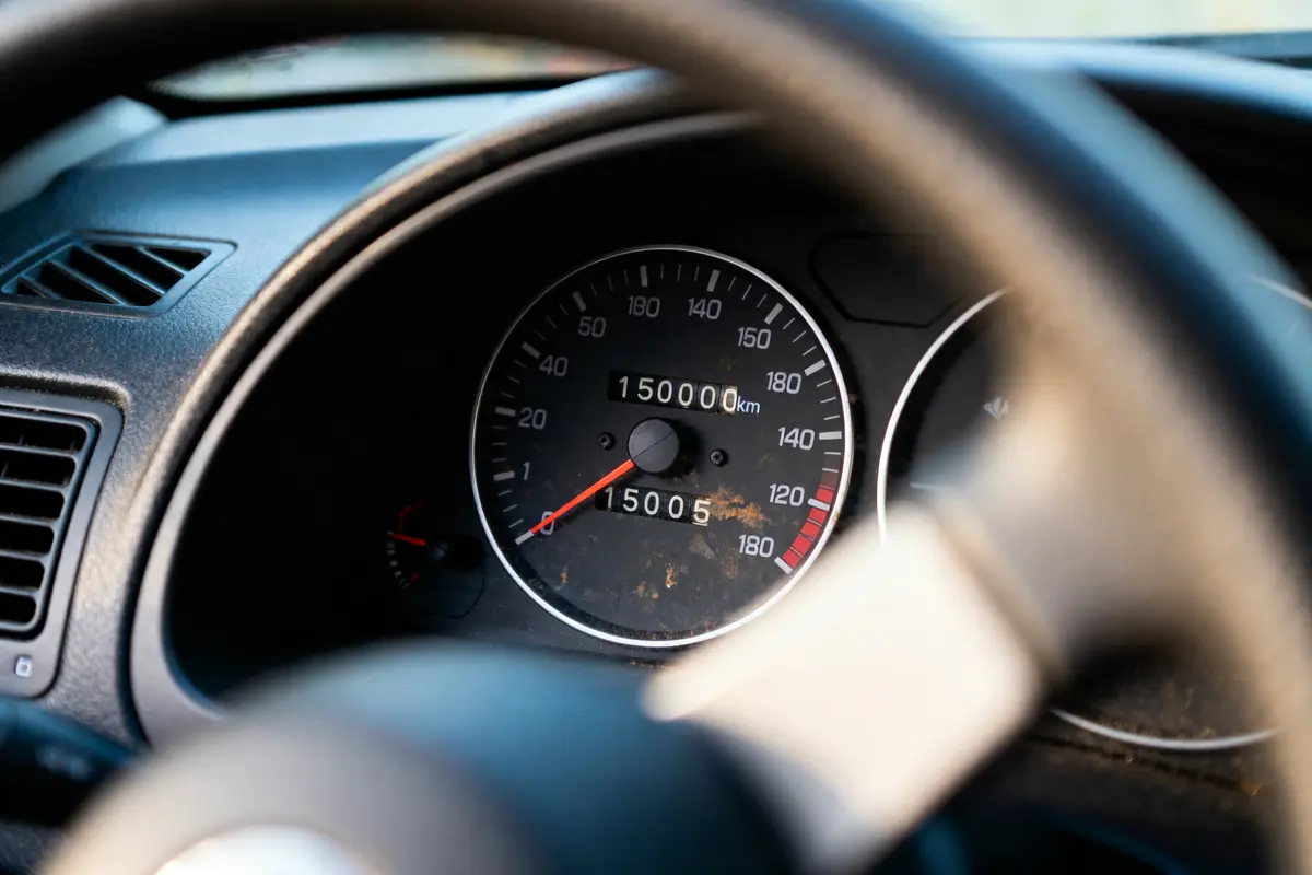 Tableau de bord de voiture affichant un compteur kilométrique à 150000 km.