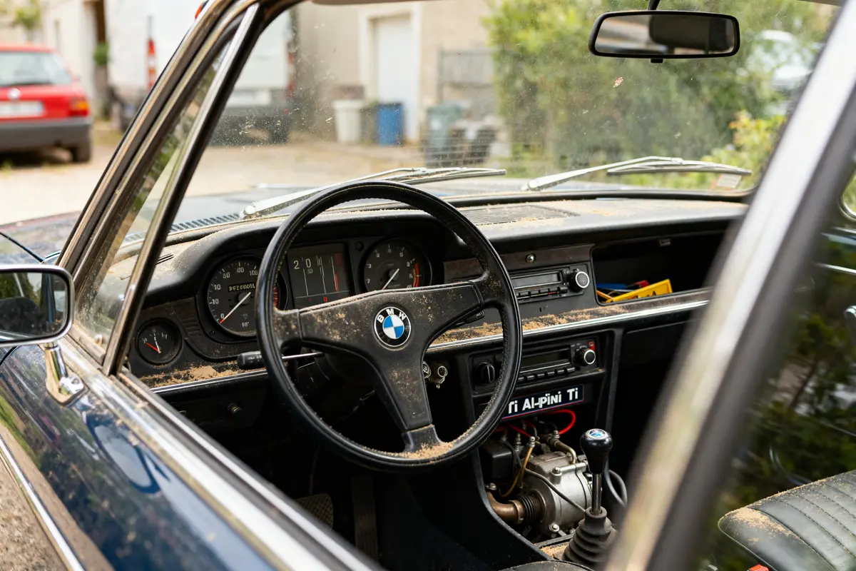 Intérieur d'une BMW ancienne avec volant et tableau de bord vintage en gros plan