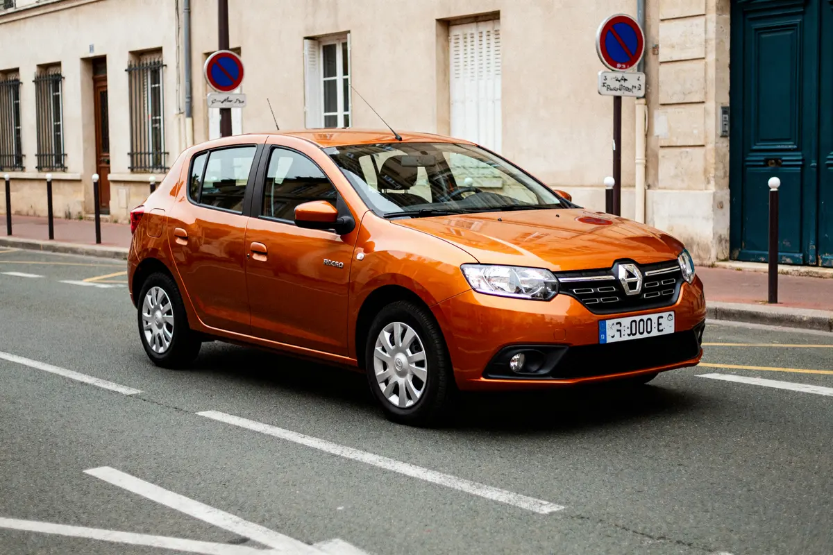 Voiture citadine orange Dacia Sandero neuve 8000 euros stationnée en ville sur rue