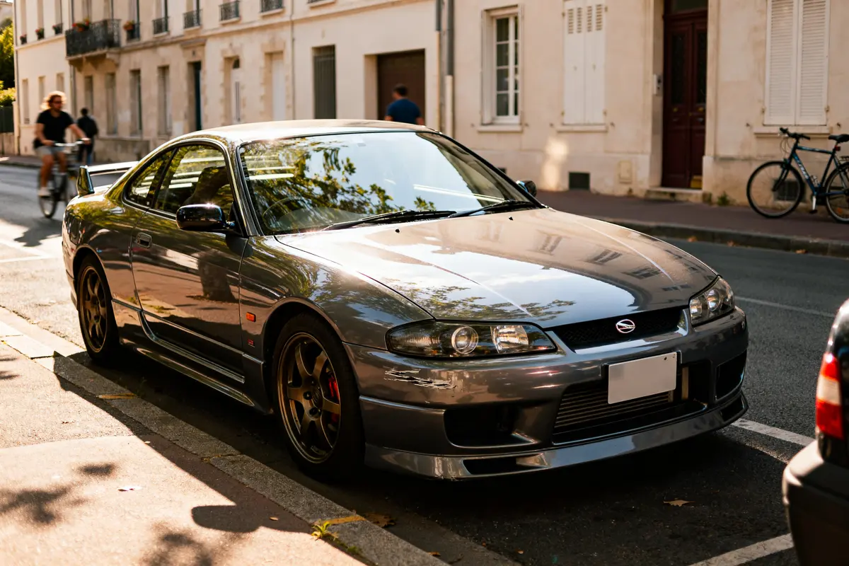 Nissan Silvia S15 gris stationné en ville, soleil reflétant sur la carrosserie