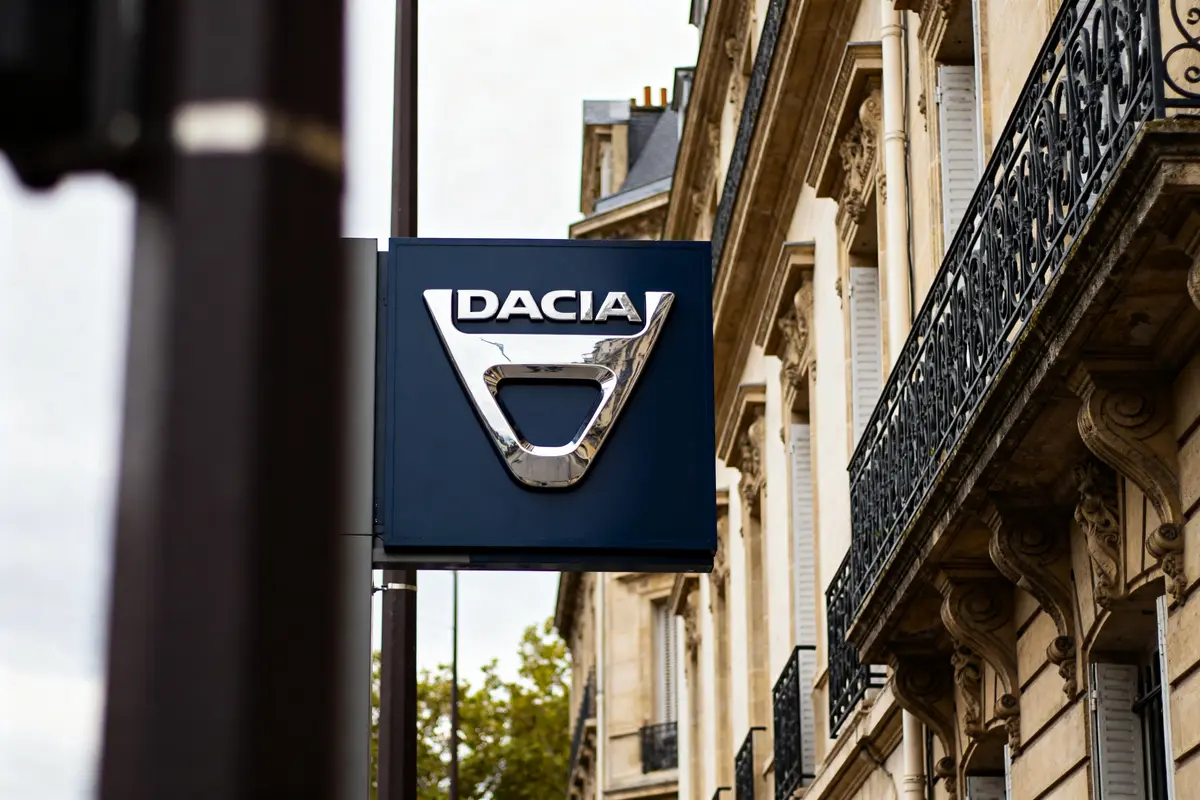 Enseigne extérieure avec le logo Dacia devant un bâtiment parisien élégant