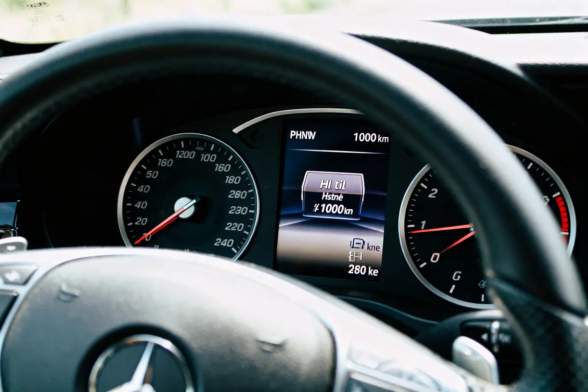 Tableau de bord de voiture affichant consommation huile 1l pour 1000 km et compteur kilométrique