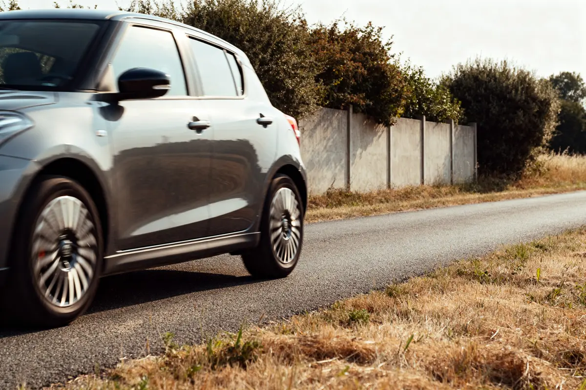 Voiture grise roulant sur route de campagne, soulignant l'efficacité de l'ebd voiture